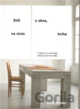 Stůl u okna, na stole kniha
